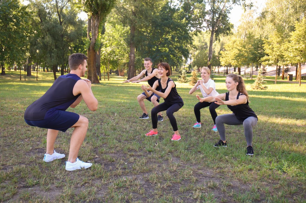 Squatting with improper form can lead to knee cartilage injuries. You may want to consult an exercise professional. Here, a trainer leads a squat class.