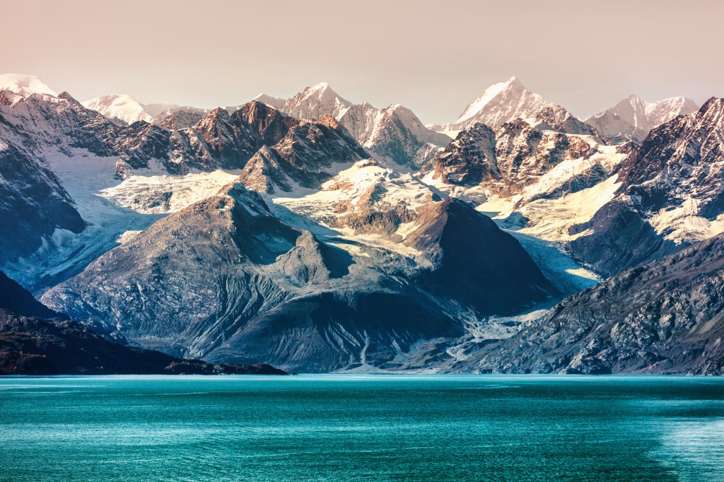 View of snow-capped mountains at sunset in Glacier Bay National Park, Alaska from a cruise ship